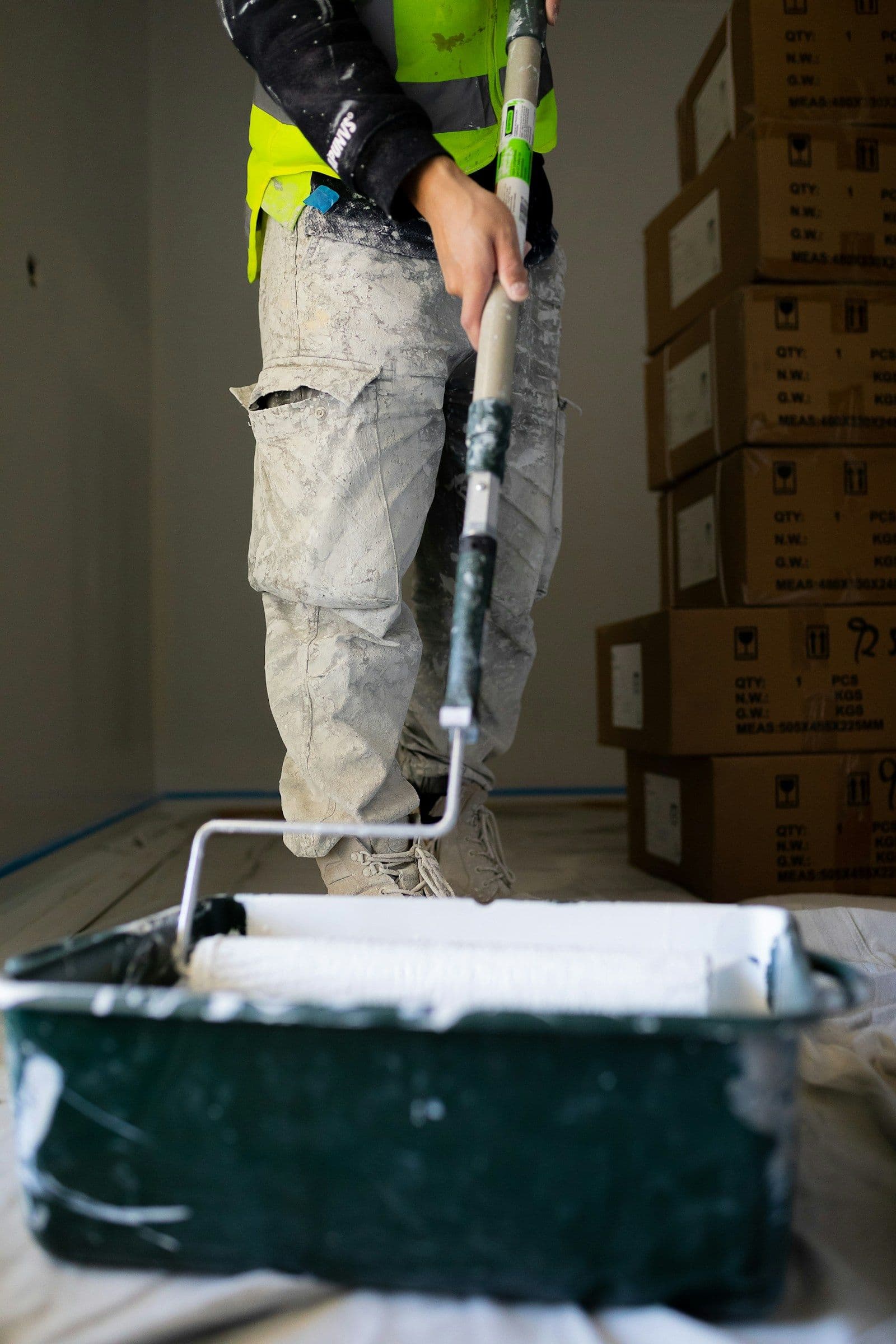 Painter applying paint to an interior wall with a roller